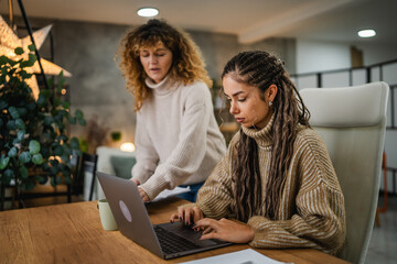 two females colleagues work together on new project at home office
