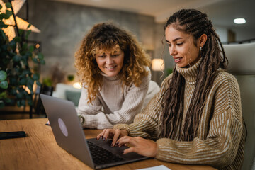 two females colleagues work together on new project at home office