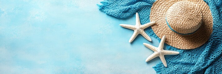 A straw hat and blue shawl are combined with starfish on a softly textured blue surface
