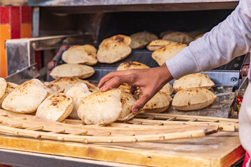 Manshiyat Naser, Garbage City, Cairo, Egypt. Baker making fresh pita bread, known as aish,.