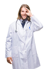 Young handsome doctor man with long hair over isolated background doing ok gesture with hand smiling, eye looking through fingers with happy face.