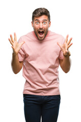 Naklejka premium Young handsome man over isolated background celebrating crazy and amazed for success with arms raised and open eyes screaming excited. Winner concept