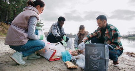 People finished bringing trash to one location. Starting placing everything into specific bags....