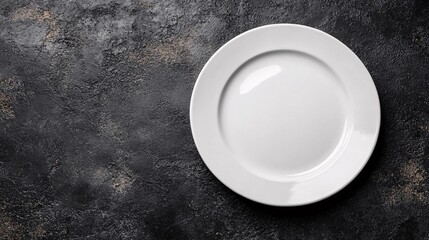 Plain white plate on a textured black background highlighting minimalistic presentation