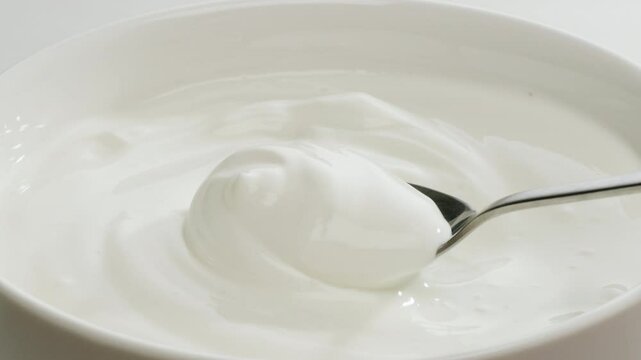 Pouring kefir yogurt into glass cup close-up. Glass with kefir or milk, lactic acid product dairy products concept. Drinking fresh lactose free in morning.