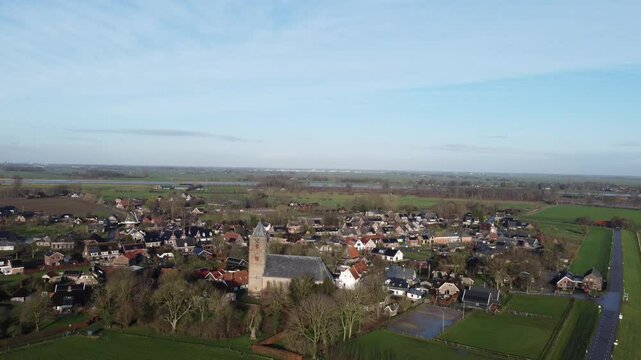 Zalk, the Netherlands - January 8th 2025: Aerial footage of the village of Zalk. Drone is moving away backwards from the Sint Nicolaas church. 