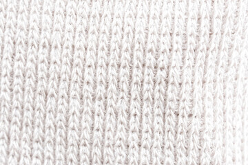 Textured white knit fabric showcases intricate weaving patterns and soft fibers suitable for cozy apparel and home textiles. Photo