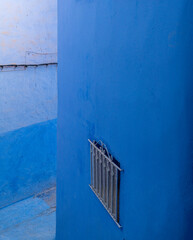 Africa, Morocco, Chefchaouen. Blue walls and metal window cover.