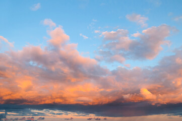 Fototapeta premium Sunset sky landscape, picturesque vast panoramic view of pink and orange sky clouds lit by evening sunlight. Sweeping sky landscape panoramic scene