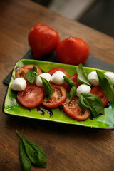 Caprese salad featuring fresh mozzarella, tomatoes, and basil arranged artistically on a plate