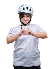Young adult cyclist woman with down syndrome wearing safety helmet over isolated background smiling in love showing heart symbol and shape with hands. Romantic concept.