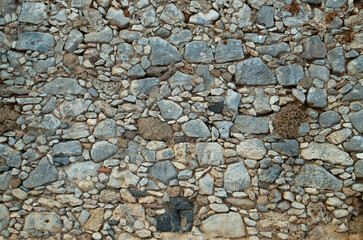 Old  stone wall with small and big pieces close up