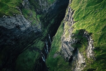 Majestic green cliffs cradle a hidden waterfall in a remote canyon at dawn beneath a clear sky