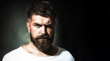 Fototapeta premium Man portrait. Handsome bearded man with stylish hairstyle. Serious pensive man with beard and mustache in casual clothes. Fashionable unshaven male model in white sweater. Copy space for advertising.