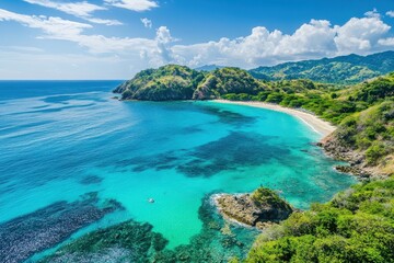 Obraz premium Breathtaking coastal view showcasing turquoise waters and lush greenery under a bright blue sky at a tranquil beach