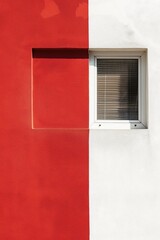 Fototapeta premium Minimalist red and white wall with a window and shadow details