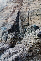 Close-up of layered, rocky terrain. Erosion patterns visible. Natural geological formations. Piha, Auckland, New Zealand