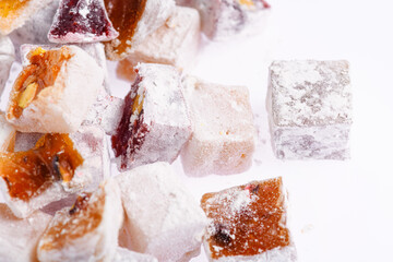 Sweet food Turkish delight, assorted rahat locum in form of cubes with nuts and powdered sugar, traditional food, on white background