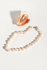 Necklace made of natural cultured pearls. Beads and seashell on white background. Pink pearls