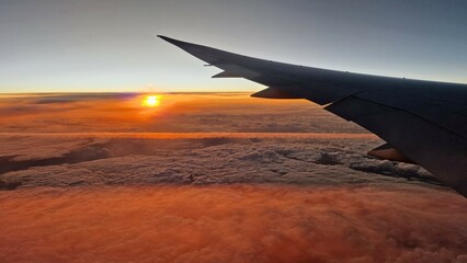 Obraz premium view wing and clouds sunrise commercial airplane passengers