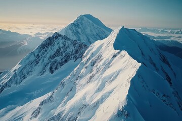 Majestic snow-covered mountain peaks under a clear blue sky at sunrise