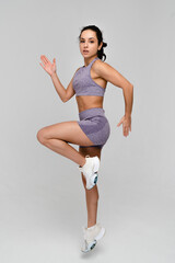 Fitness workout. Sport woman fitness trainer exercising, jumping on white background. Full length...