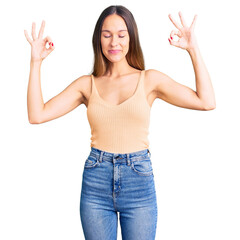 Beautiful brunette young woman wearing casual clothes relax and smiling with eyes closed doing meditation gesture with fingers. yoga concept.