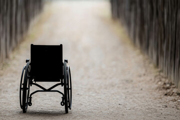 Obraz premium A black wheelchair is sitting on a dirt road