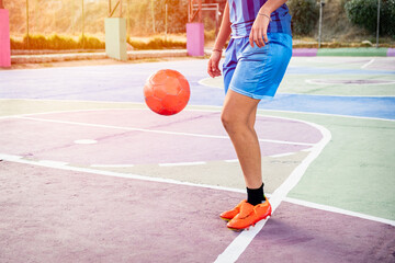 close-up of legs of latina female soccer player practicing in blue sportswear on an outdoor soccer...