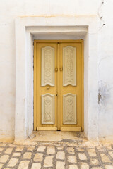 Kairouan, Tunisia. A yellow door in a white building.
