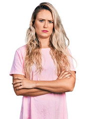 Young blonde woman with arms crossed gesture skeptic and nervous, frowning upset because of problem. negative person.