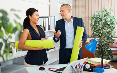 Portrait of two positive business colleagues going to training after working day in office