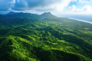 Obraz premium Lush tropical mountains bathed in sunlight overlooking the coastal landscape on a clear day