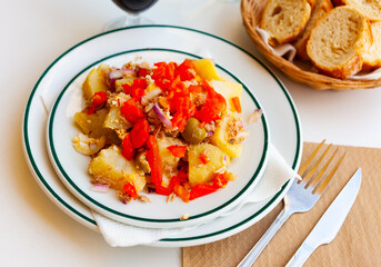 Hearty colorful potato salad with fried red pepper, canned tuna and eggs