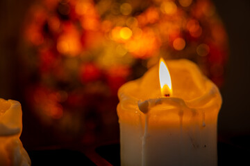A beautifully illuminated candle set against a stunning bokeh background creates a serene ambiance