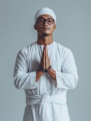 a handsome young Indonesian man wearing a long white Muslim dress with various expressions and a traditional head covering on his head, mockup style