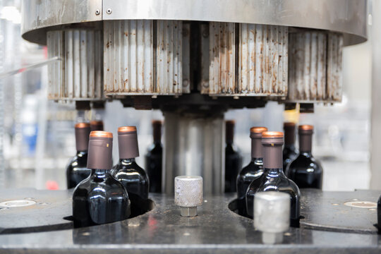 Bottling machine sealing Vinegar bottles on a production line