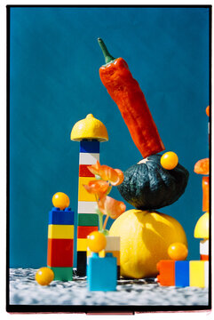 Colorful arrangement of fruits and blocks on a patterned surface