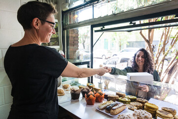Customer paying cash in takeout window shop