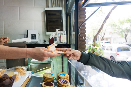 Anonymous hands exchanging money at take out window