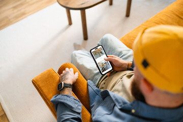 A man uses a mobile phone at home