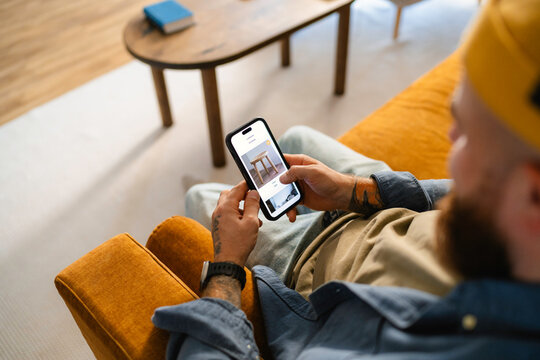 A man uses a mobile phone at home