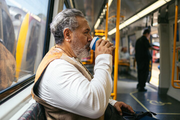 Senior man commuting on the subway to work.
