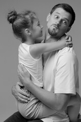 Father and daughter share a playful moment of love and joy during a candid portrait session