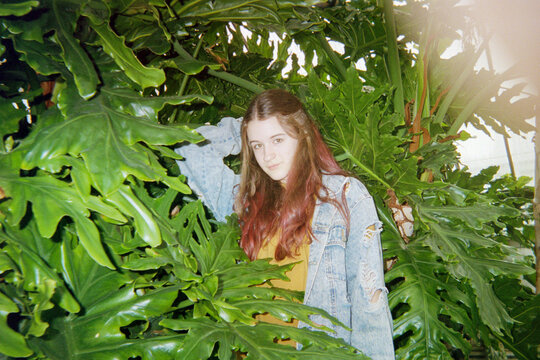 Young Woman Stands in Large Plant