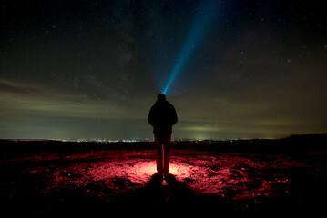 Man with headlight looking at the stars