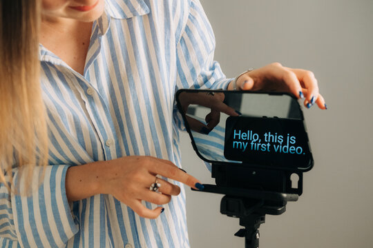 Woman setting up teleprompter with smartphone for video recordin