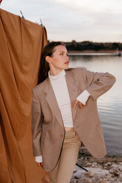 Confident woman in stylish jacket on shore