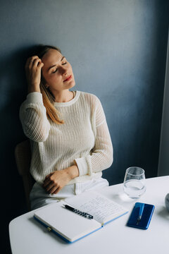Serene woman leaning back, eyes closed, enjoying a moment of rel