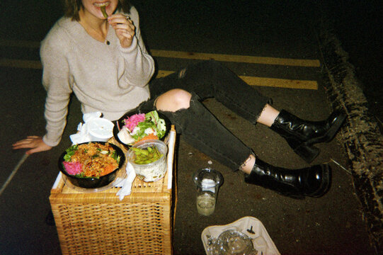 Young Woman Eats Food on a Picnic